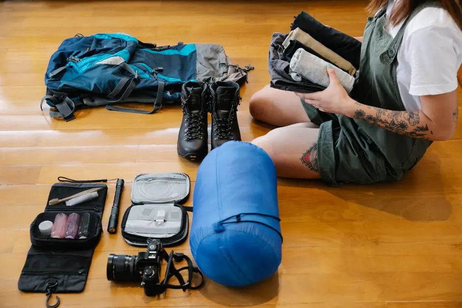 Randonneur pesant chaque objet de son sac avant un trek de plusieurs jours en montagne